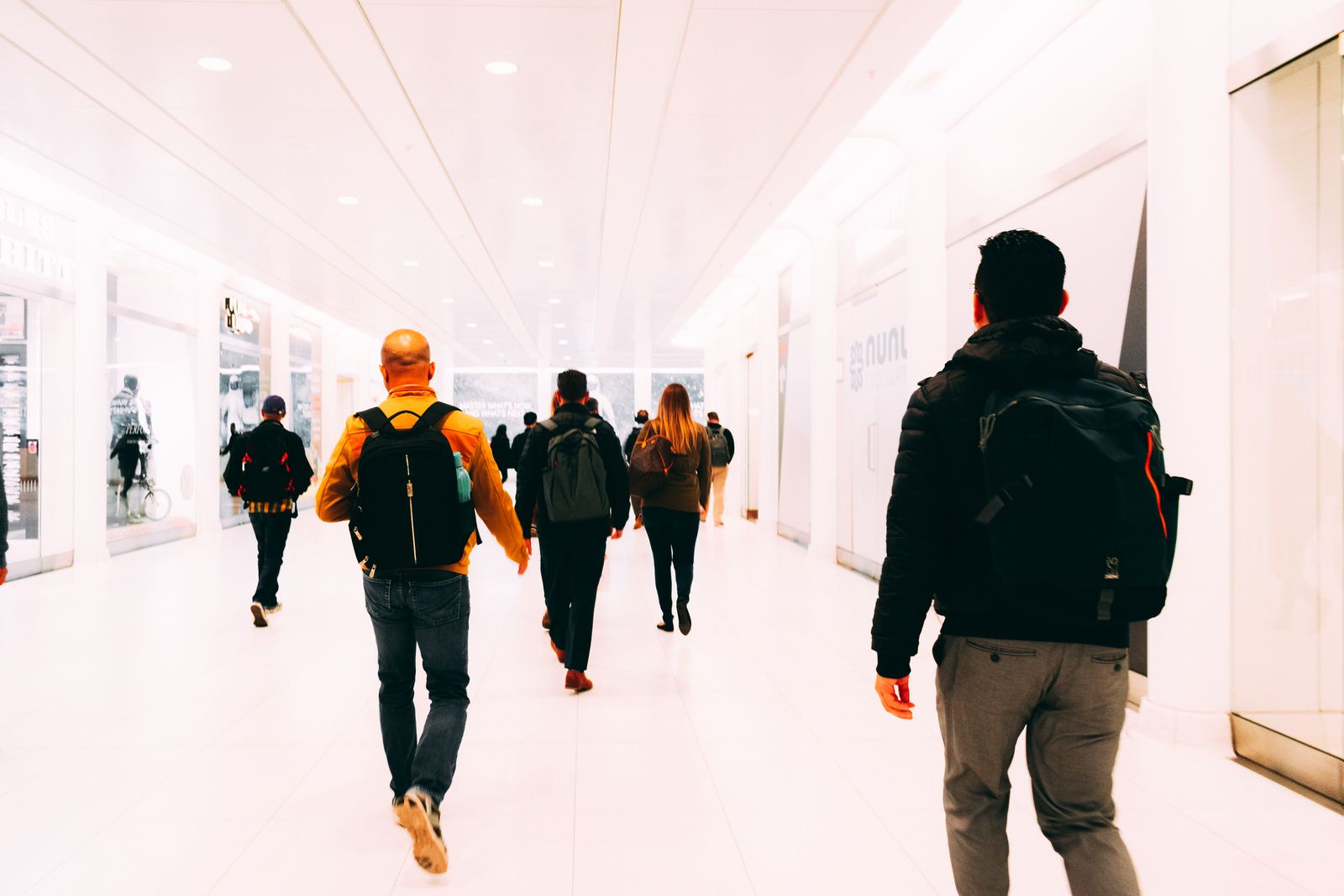 Travelers moving through a bright airport terminal