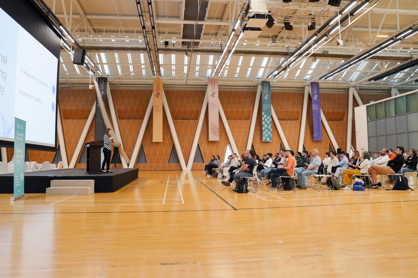 An audience listening to a presentation at a conference