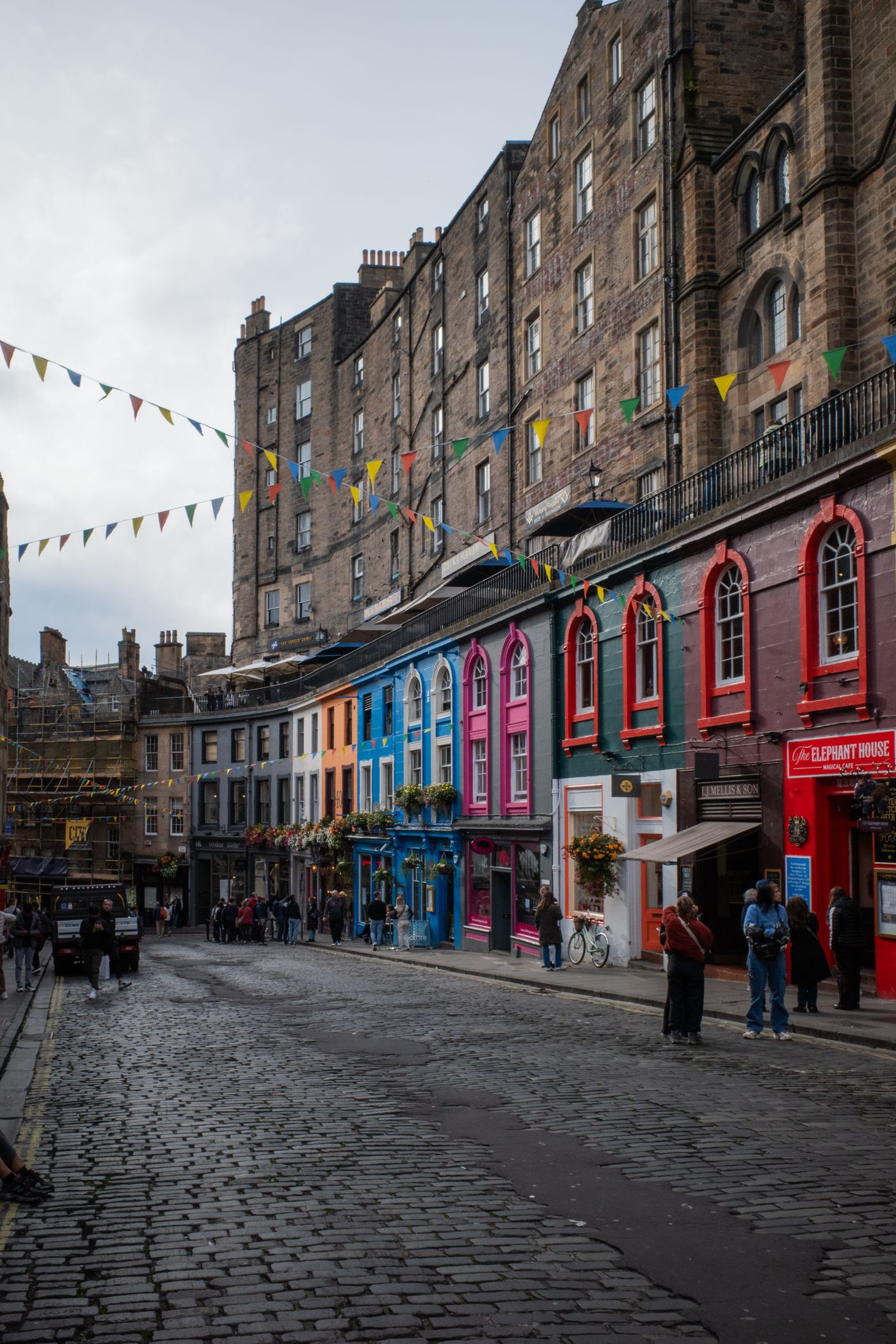 Colorful shopfronts and historic buildings on Victoria Street in Edinburgh